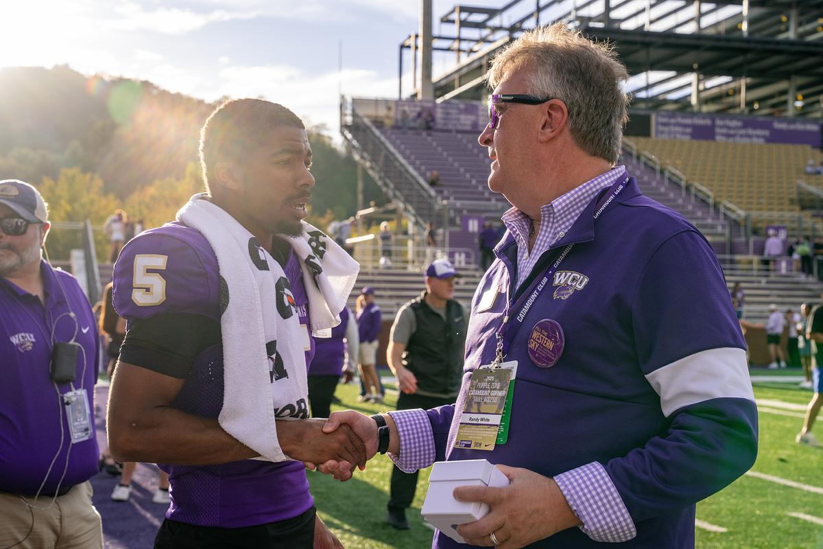 Football player shaking hands with a Catamount Coach