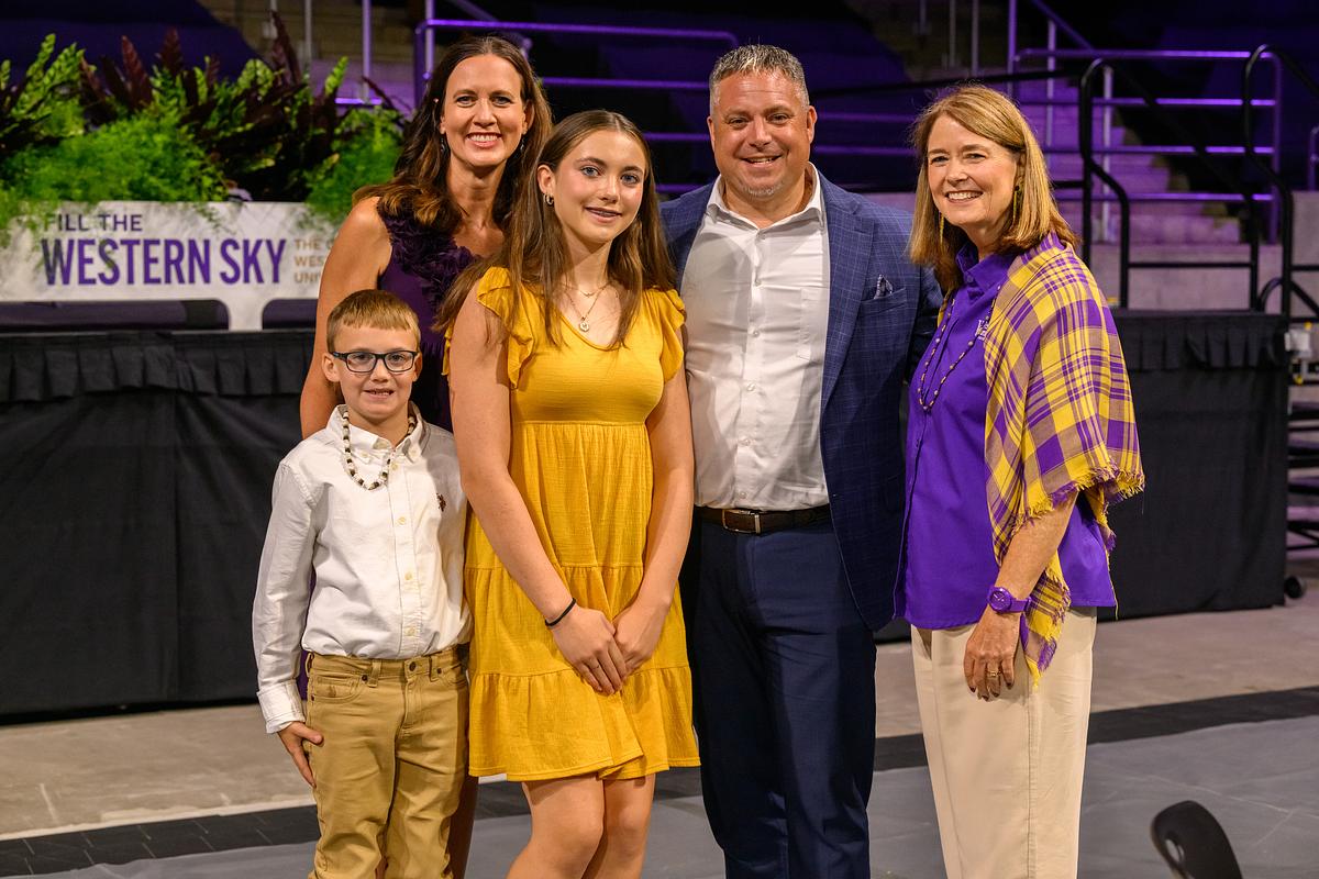 Family taking a picture with the Chancellor of the university