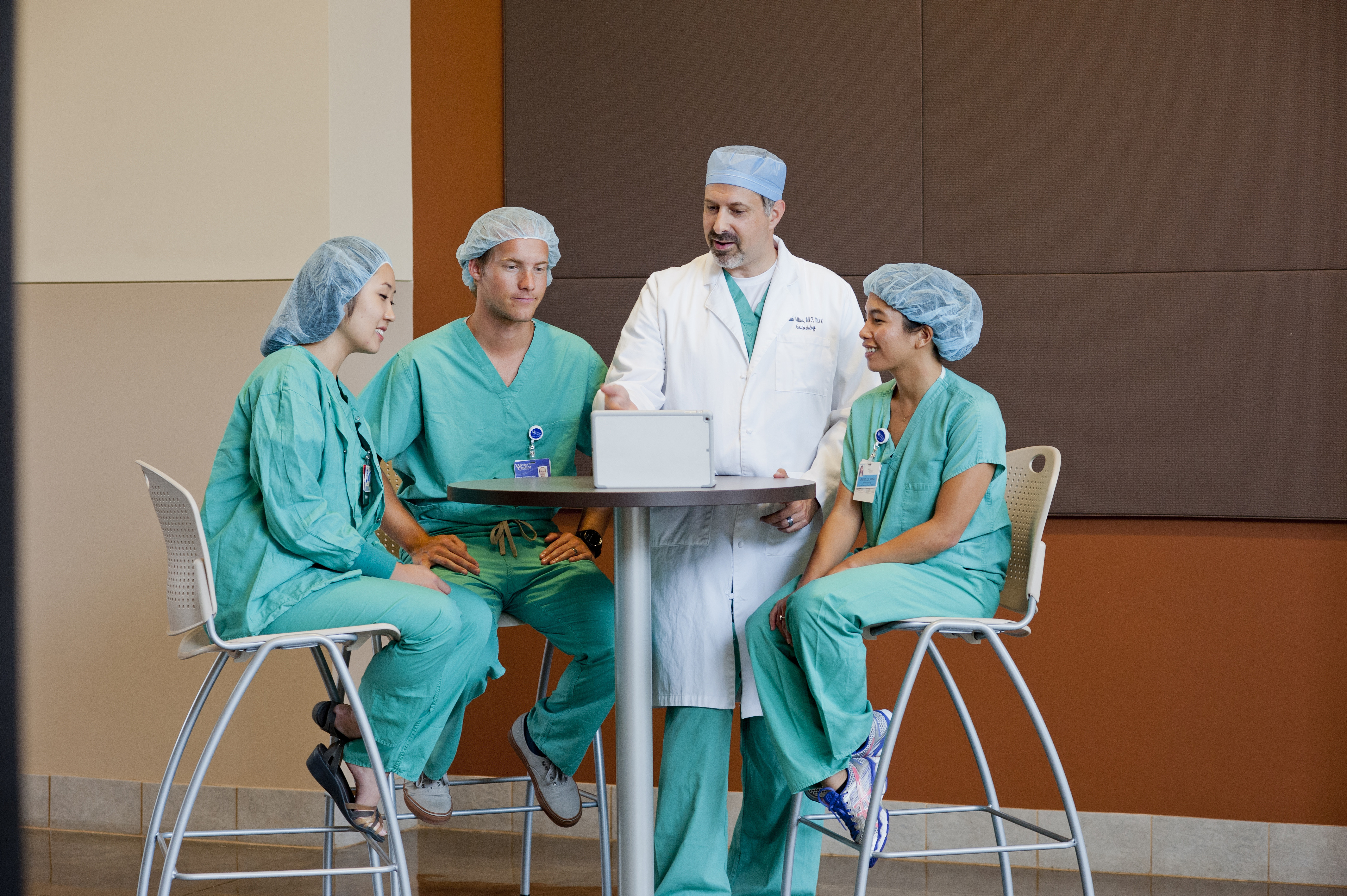 Nurse Anesthesia practitioners at a table talking as they work around a laptop