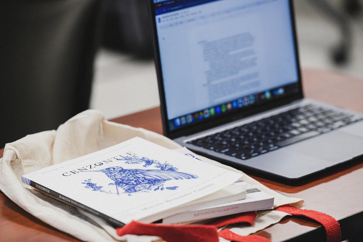 A laptop and forms sitting on a desk