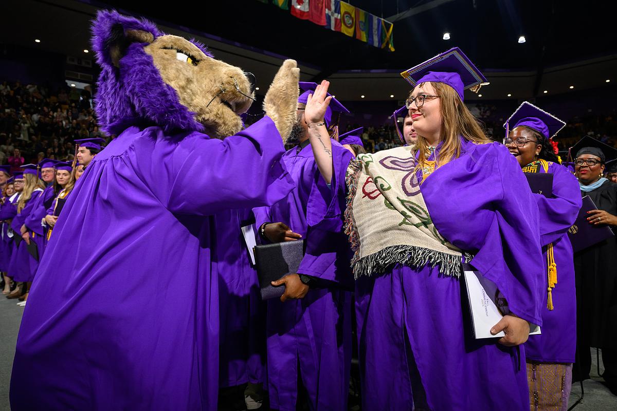 PAWs high-fiving graduating students at commencement 