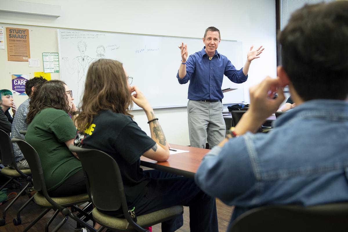 Professor John Whitmire animatedly speaking in class during a lecture