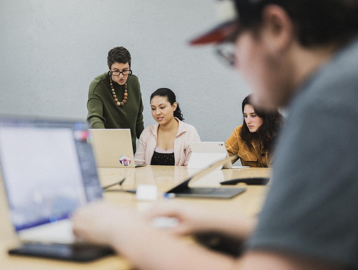 Students on their computers at a table in class
