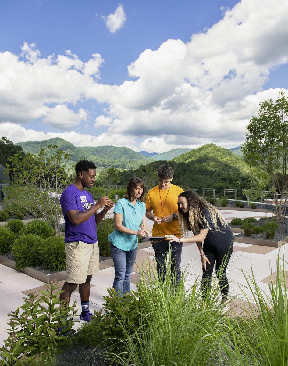 Students discussing ideas smiling and writing down information