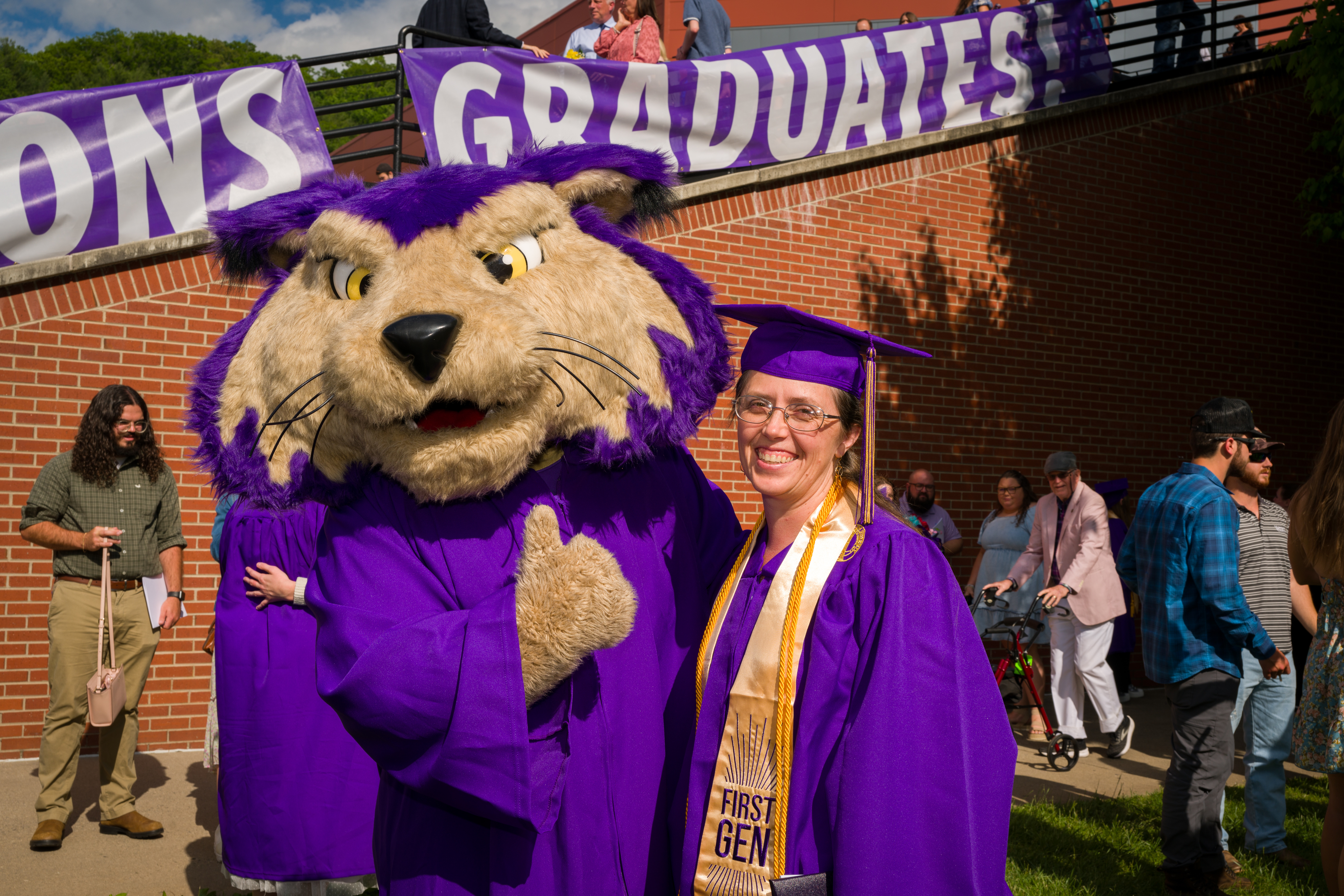 PAWS hugging a graduating student at commencement for a photo