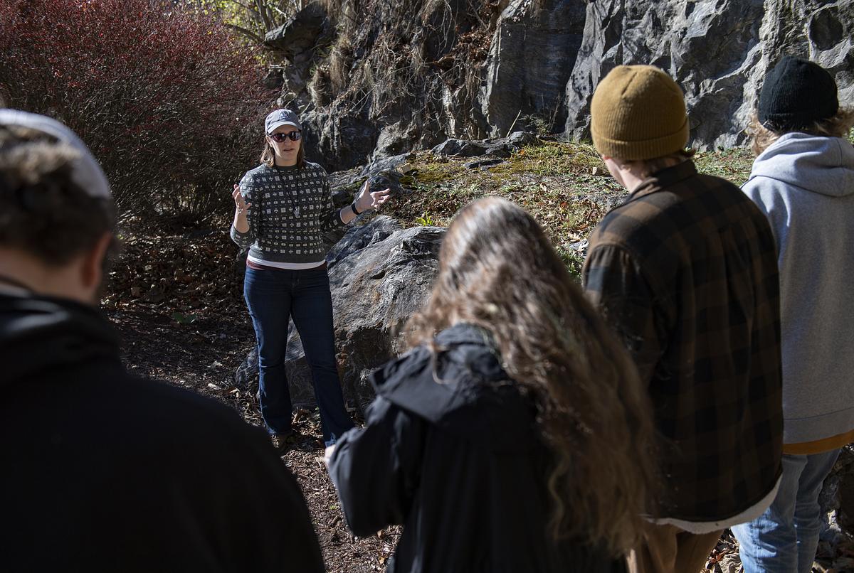 Instructor speaking to a group outside by a rock outcrop