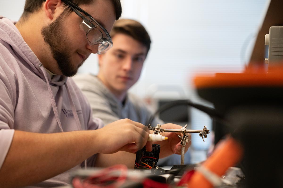 College of Engineering Technology students working with electronic and metal materials in a lab for the College of Engineering Technology