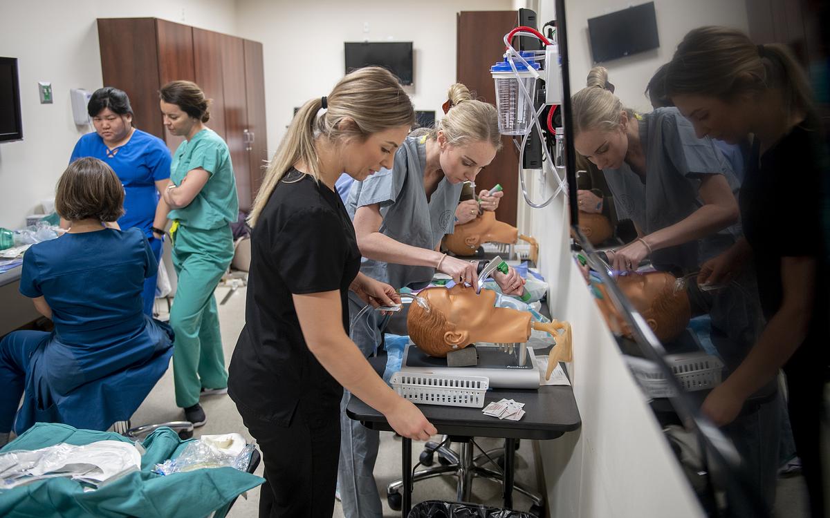 Doctor of nursing students practicing various medical procedures in a lab