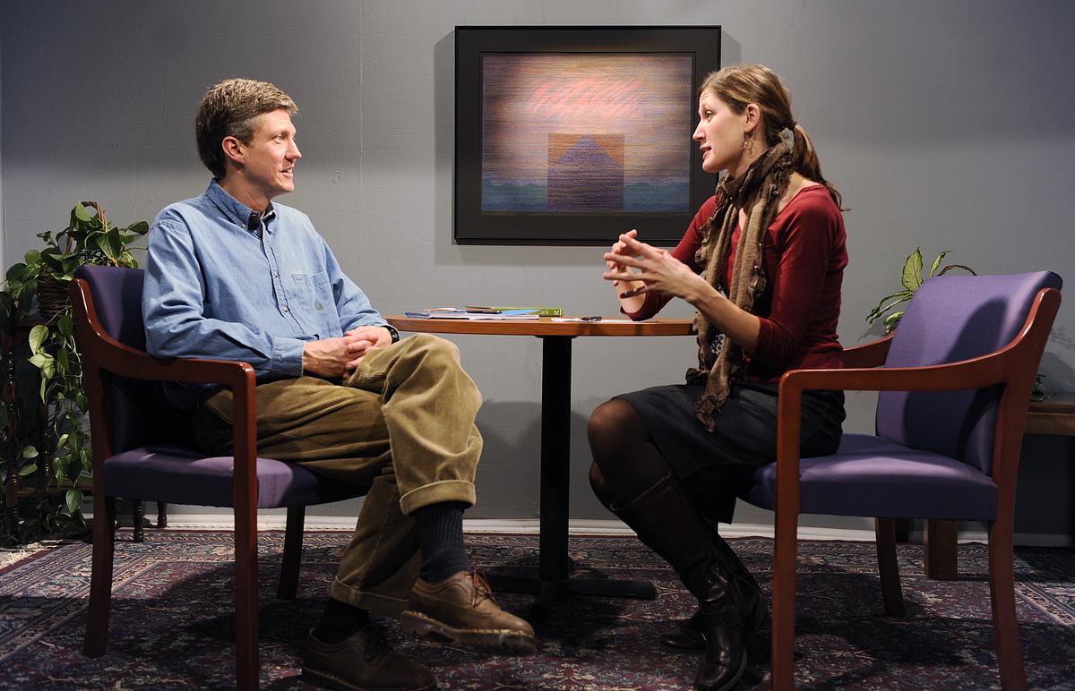 Graduate student and faculty member sittiing at a table in discussion