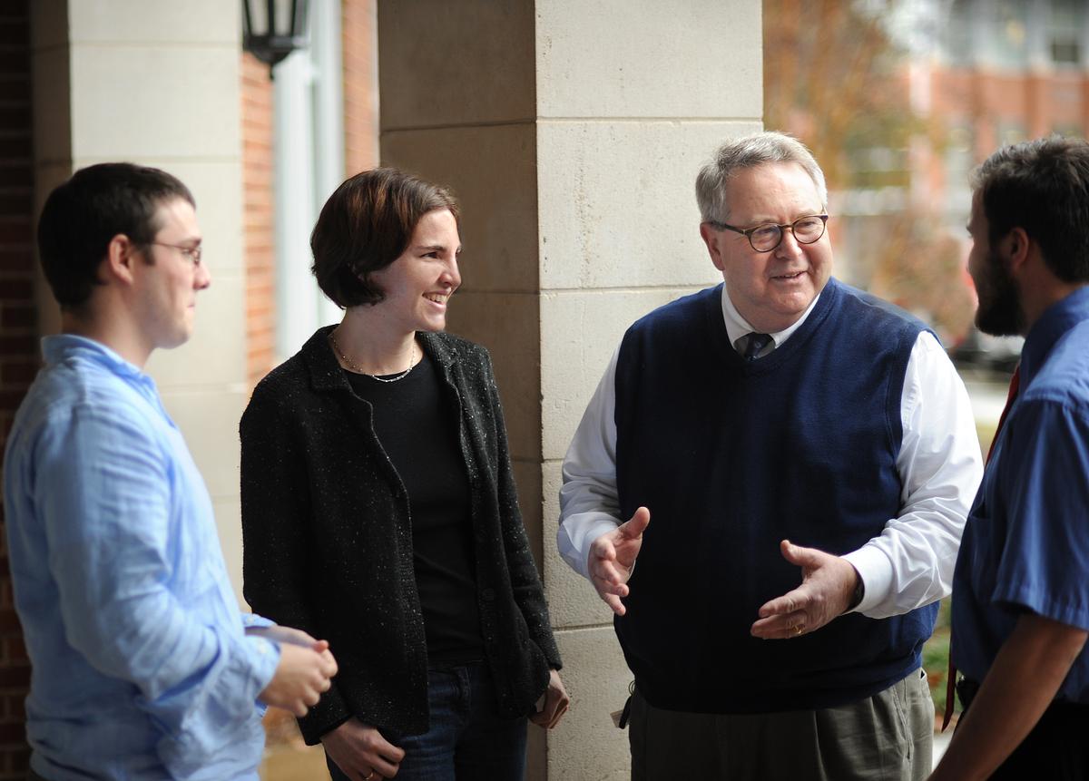Students and professor talking in a hallway