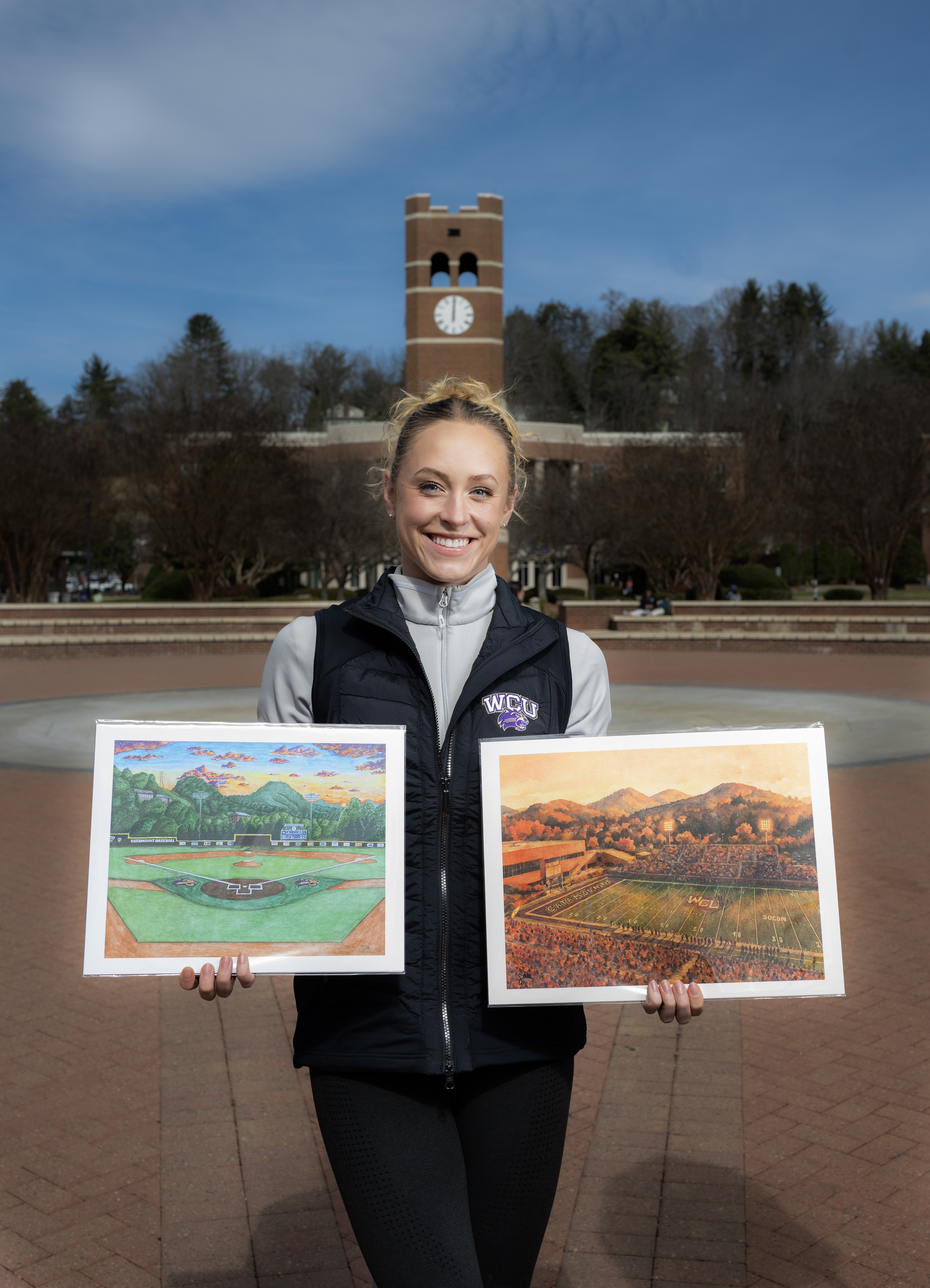 Sadler Miller holds up a pair of her prints in front of the Alumni Tower.