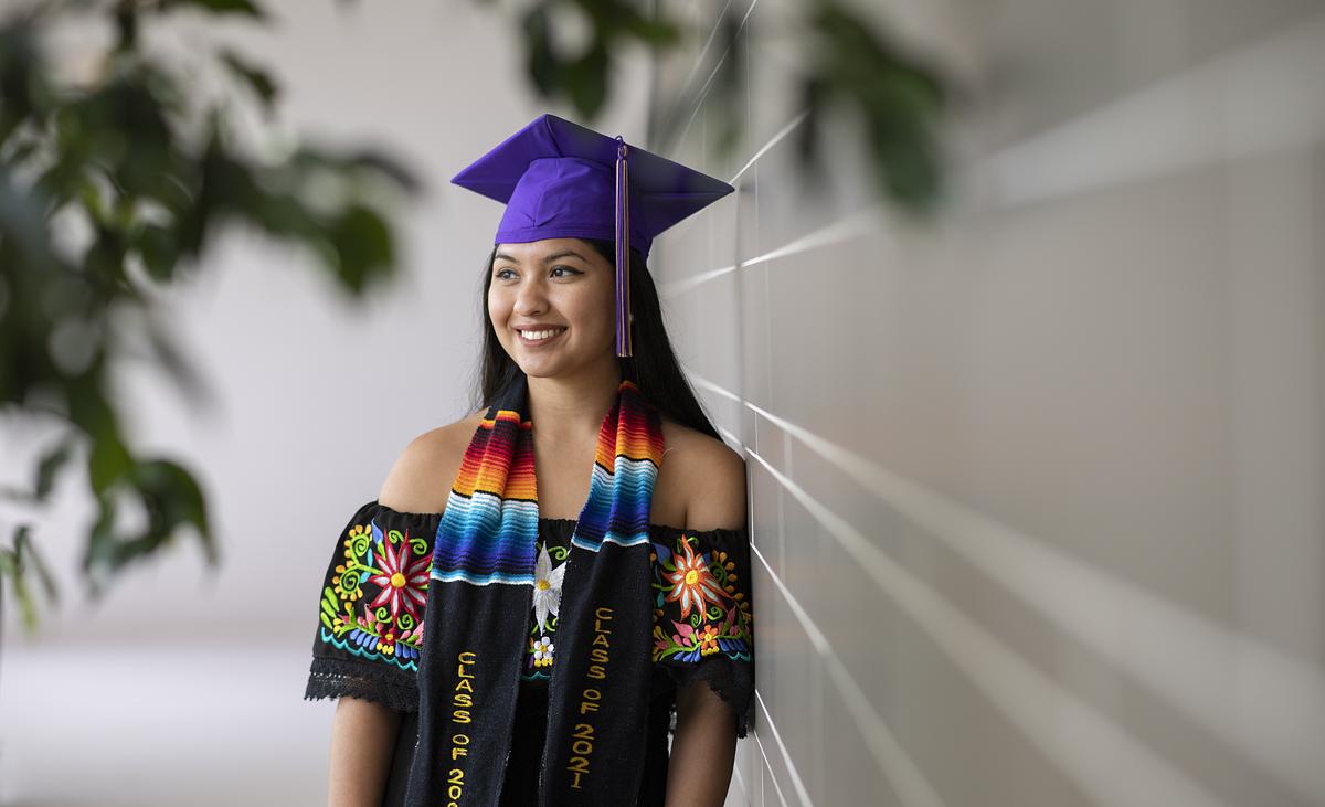 Nutrition dietetic graduate smiling for the camera in their graduation attire