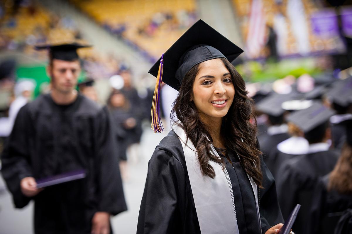 Graduating student smiling for the camera at commencement