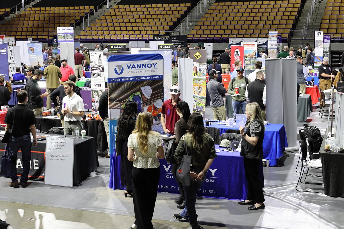 Students wandering around the Ramsey stadium visiting various booths at the English Fair