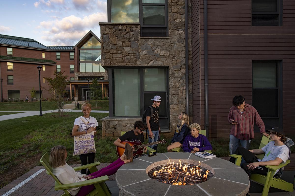 Students around a fire enjoying conversation at sunset