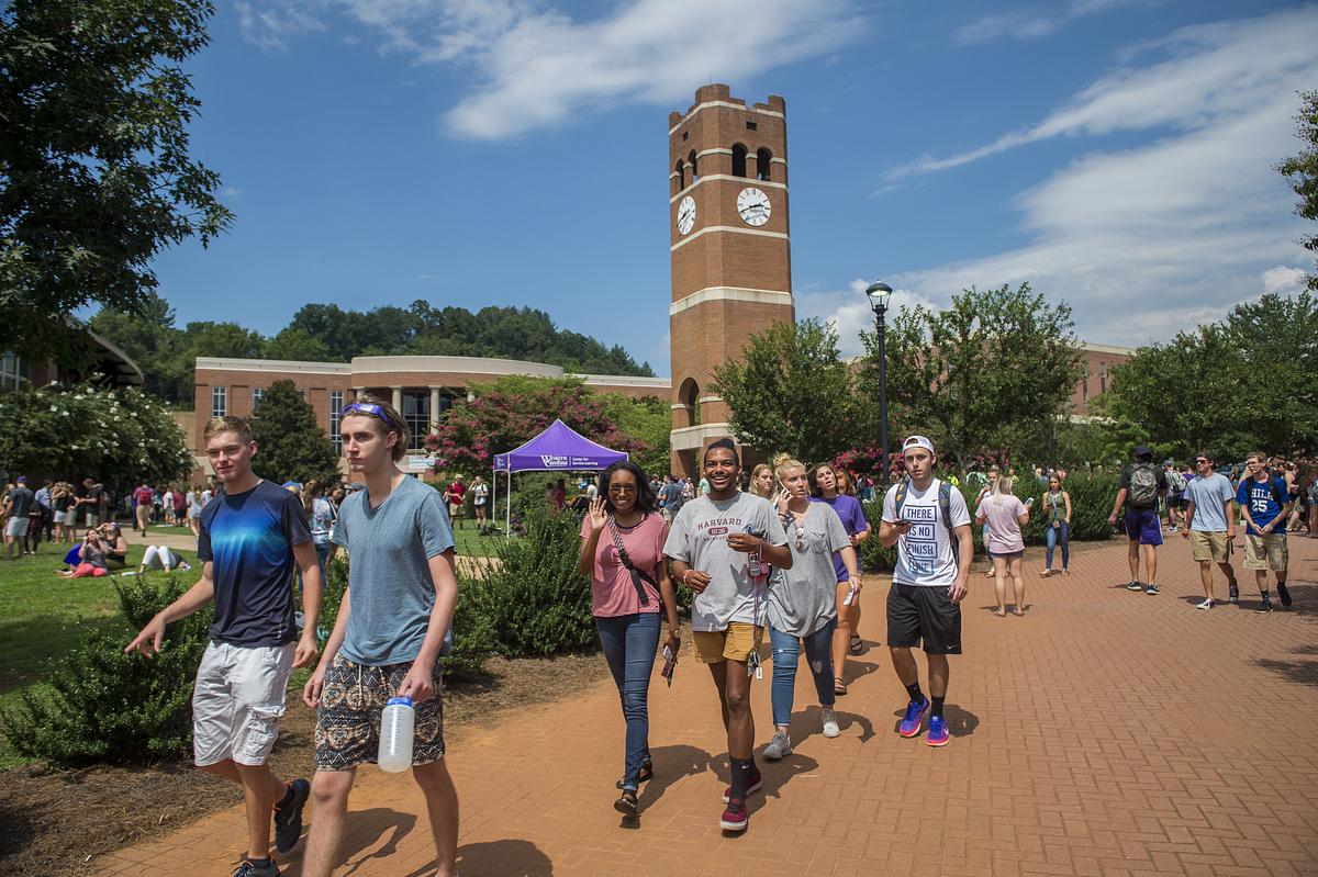 People walking on campus with the alumni tower in the background