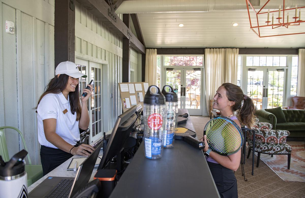 Student interns talking together at a desk, one of them holding a walkie-talkie