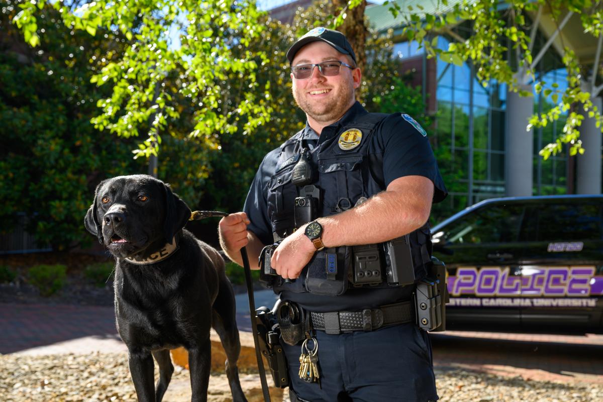 Ģ������Ƶ police officer and his K9 trainee looking at the camera together for a photo