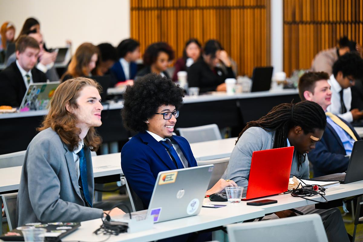 Students smiling while they listen to a lecturer in the classroom