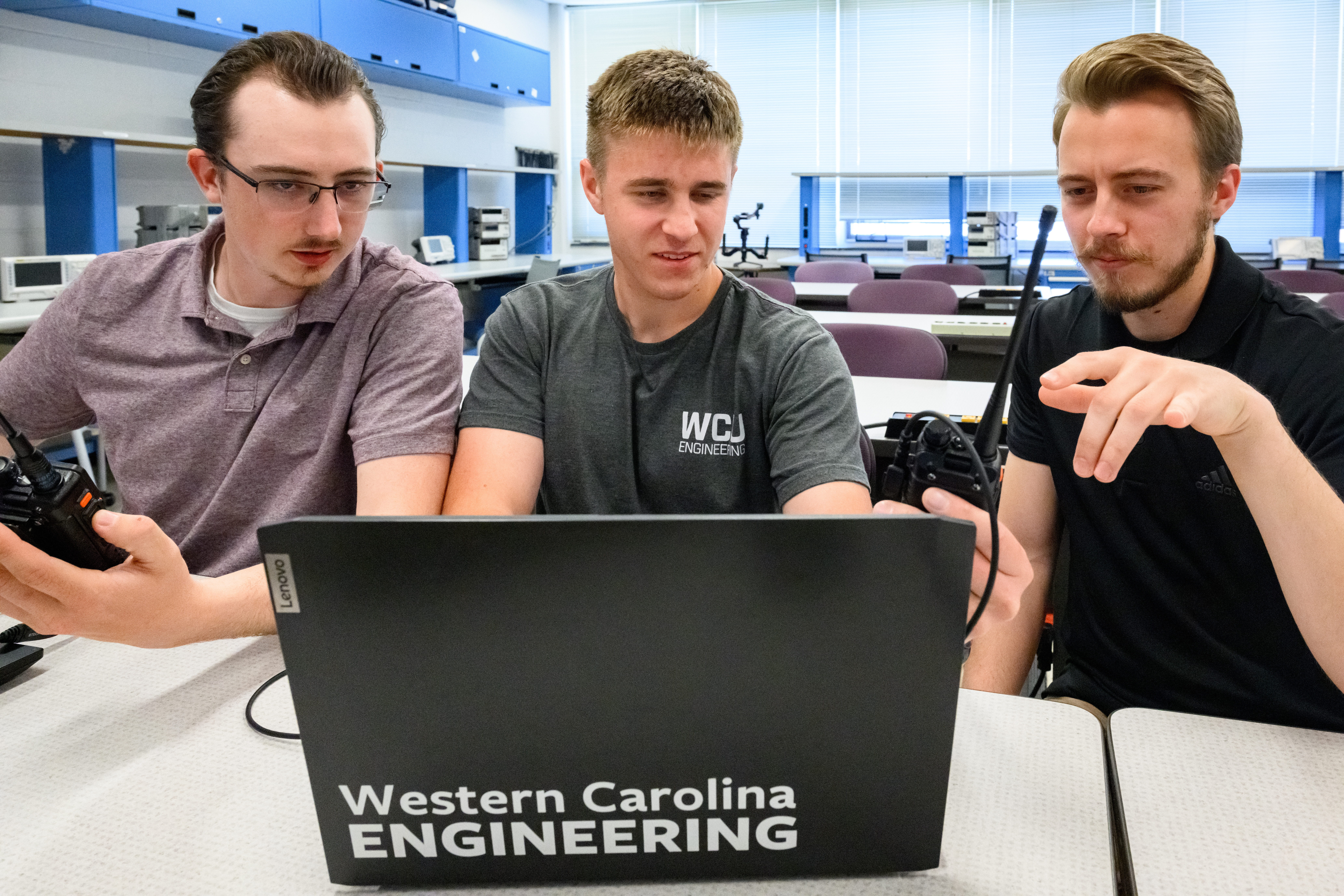 Students crowd around a laptop