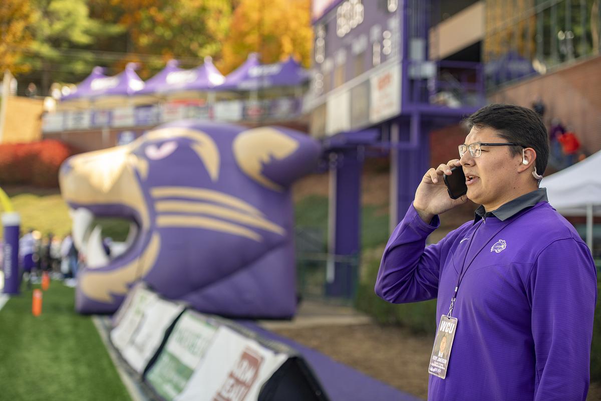 Student coach talking on the phone before a football game