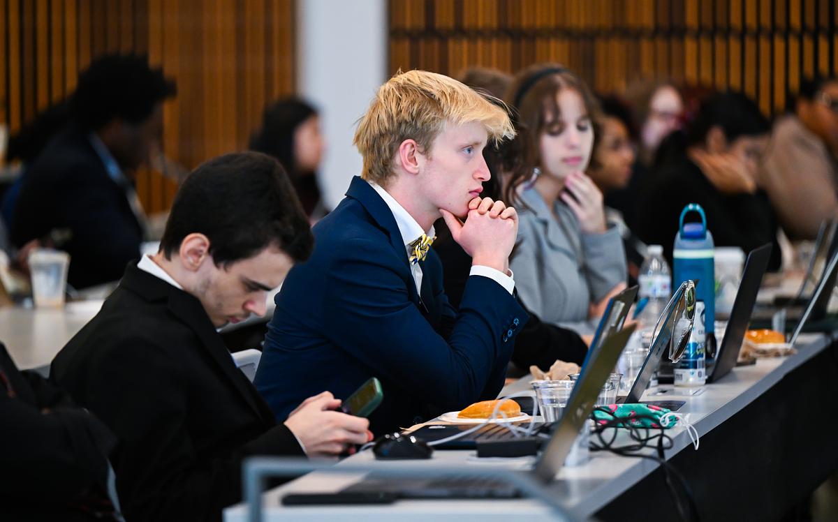 Student listens to a presentation with a full classroom