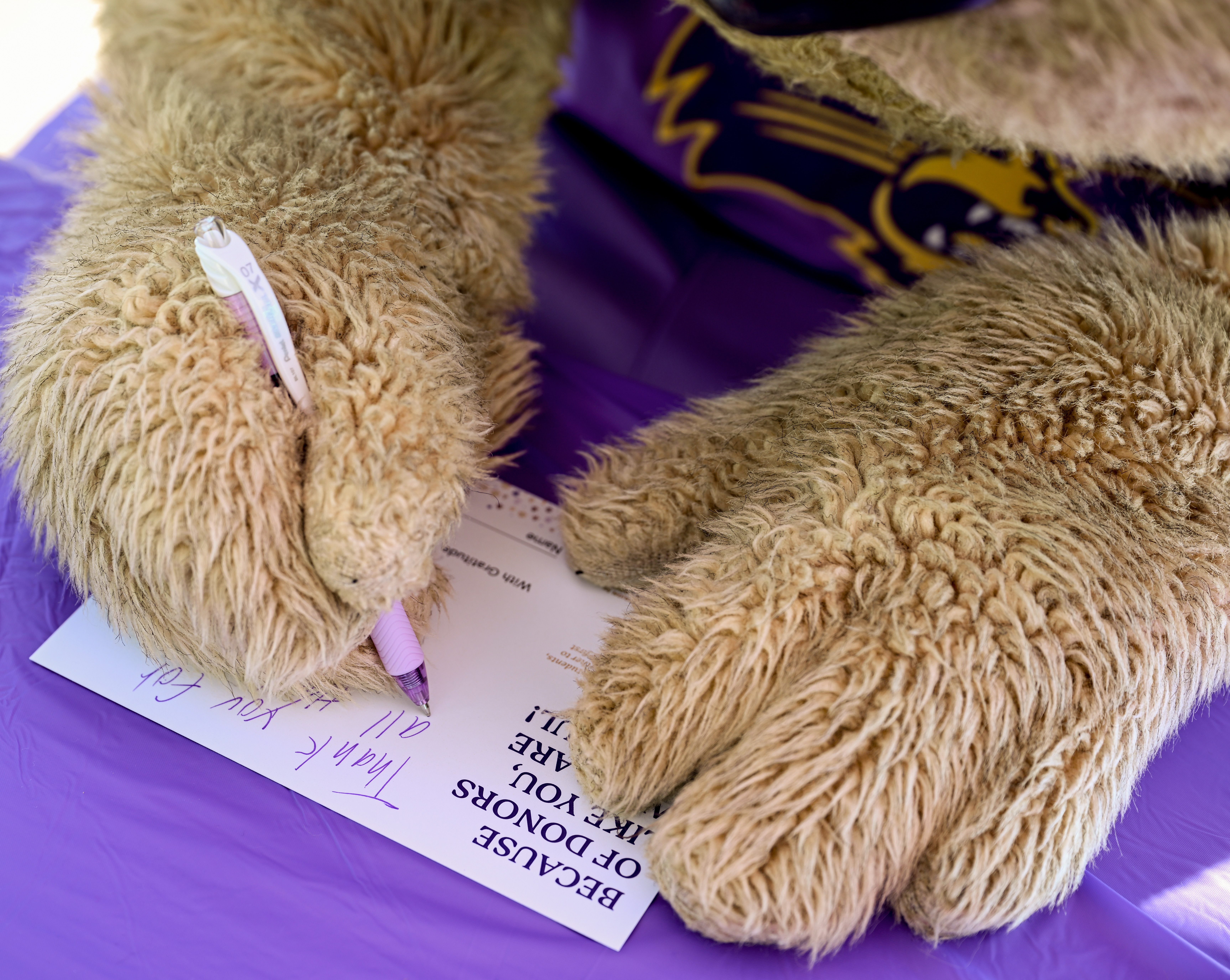 Paws signing a thank you donor card