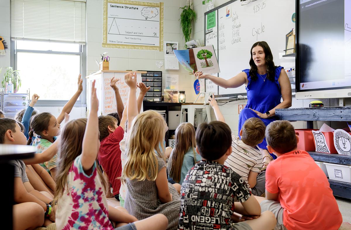 Teacher engaging with her class as she reads a book