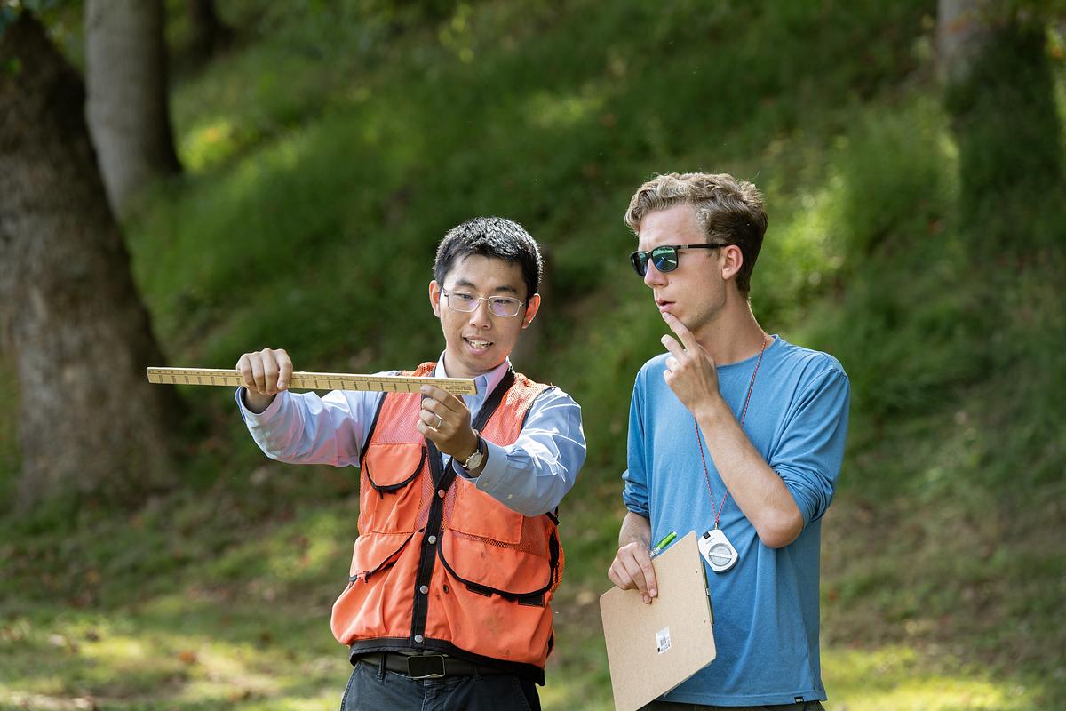 Faculty works with a student in the field