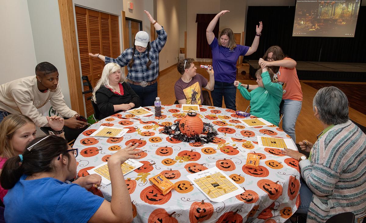 Students and physical therapists having fun around a table