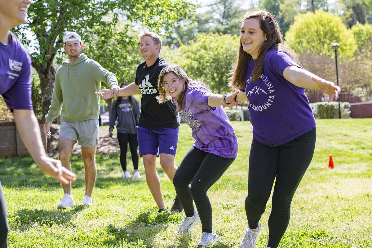 Students in class listen to a lecture and take notes while sitting in an auditorium