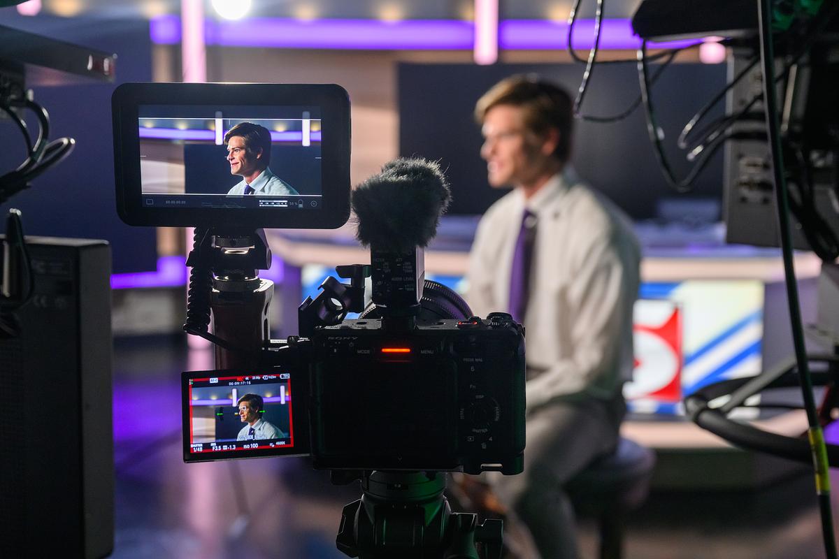 Priya showing students how to take a video with an updated video recorder