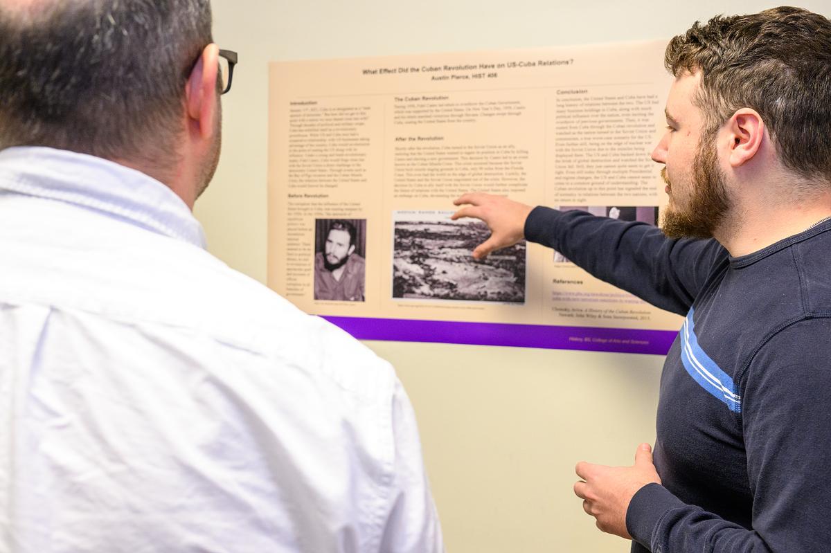 History student showing their capstone project to an audience