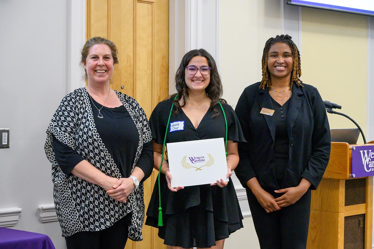 Two students holding up the Spark Award and smiling for the camera