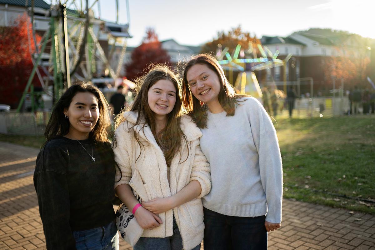 Students smiling and gathered together for a group photo at a fair