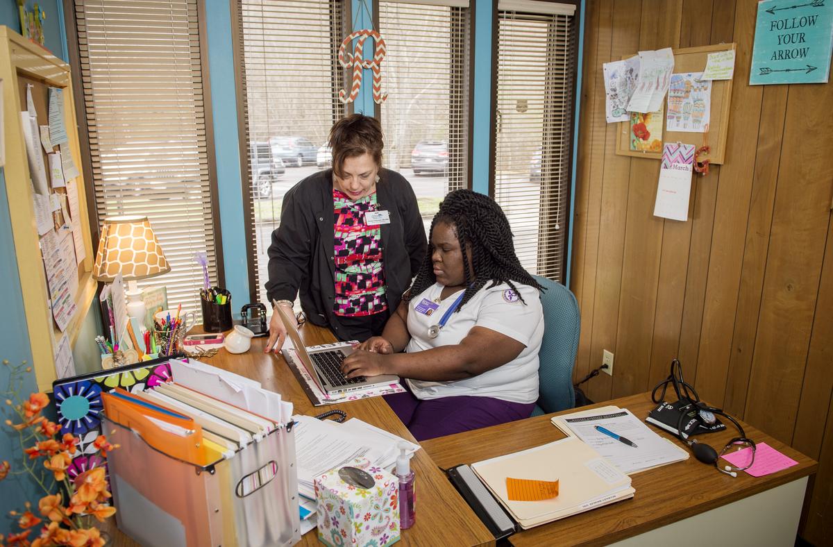 Nurse practitioners working on a laptop in an officer