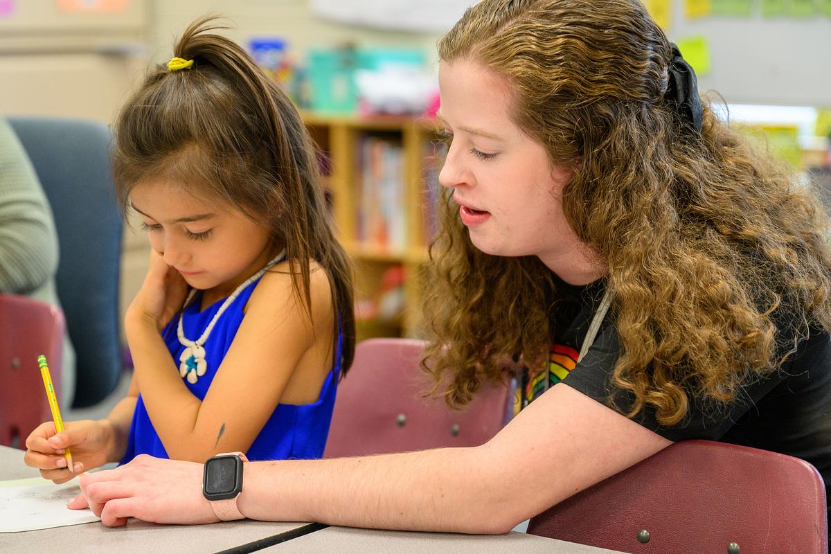 Teacher working with a student at a desk