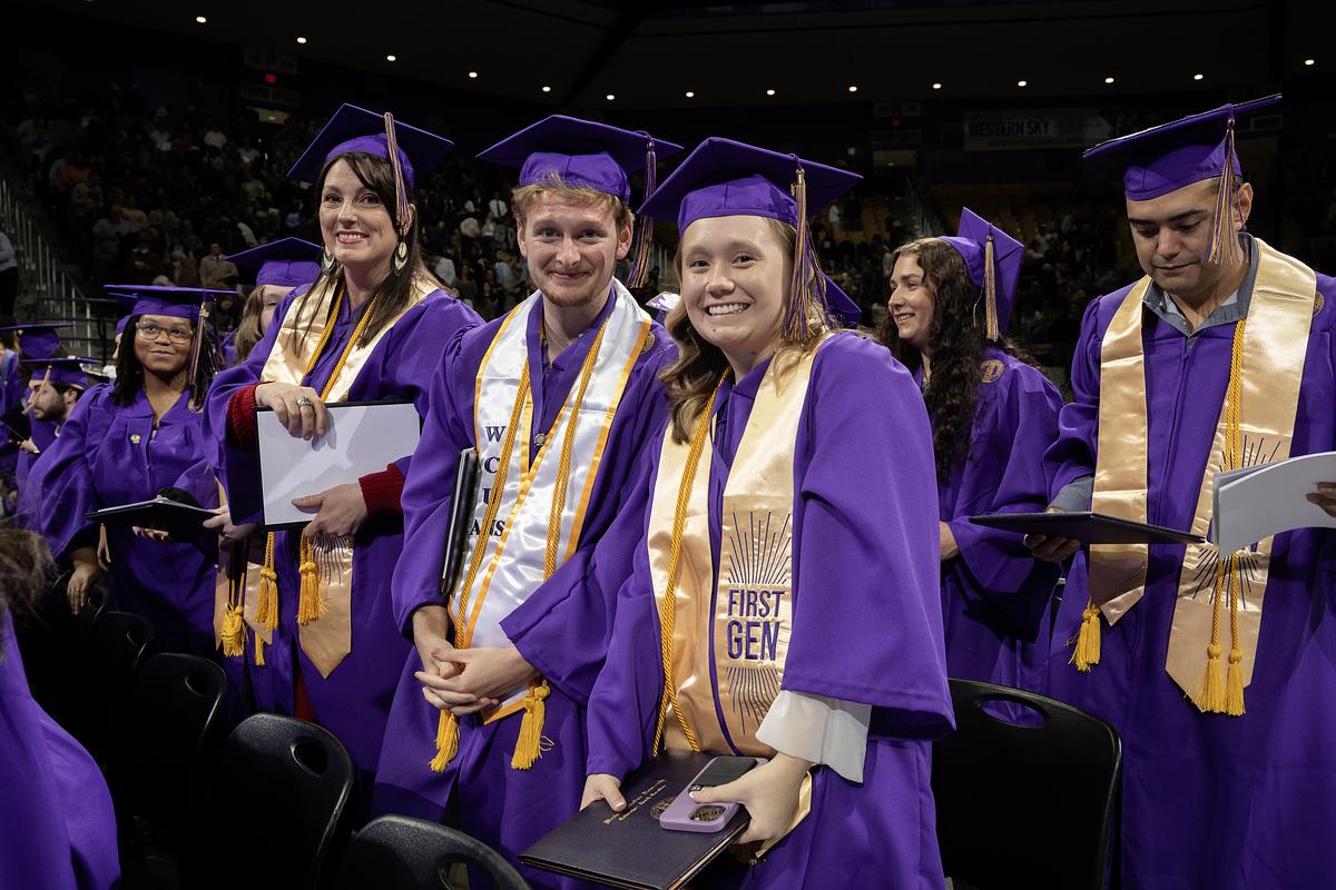 Students at graduation in purple robes and gold First Gen stole