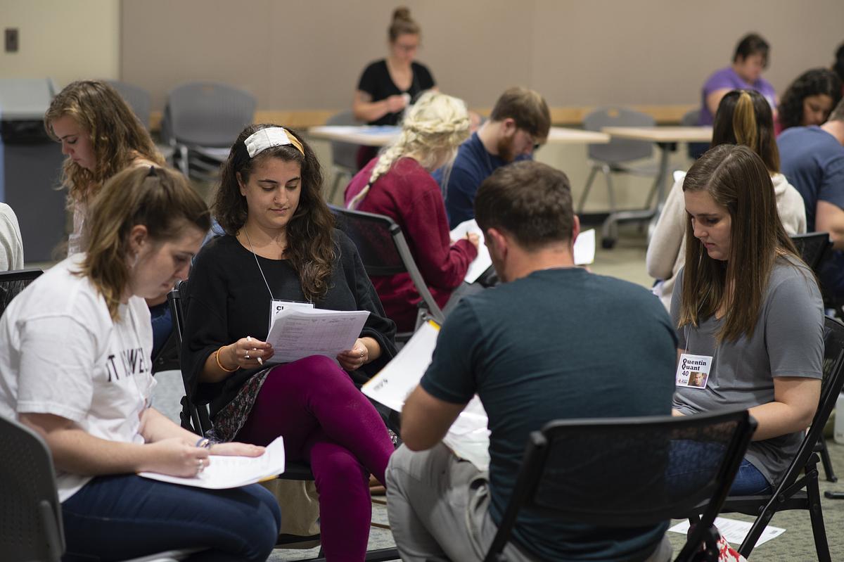 Multiple groups of students sitting and reading material together
