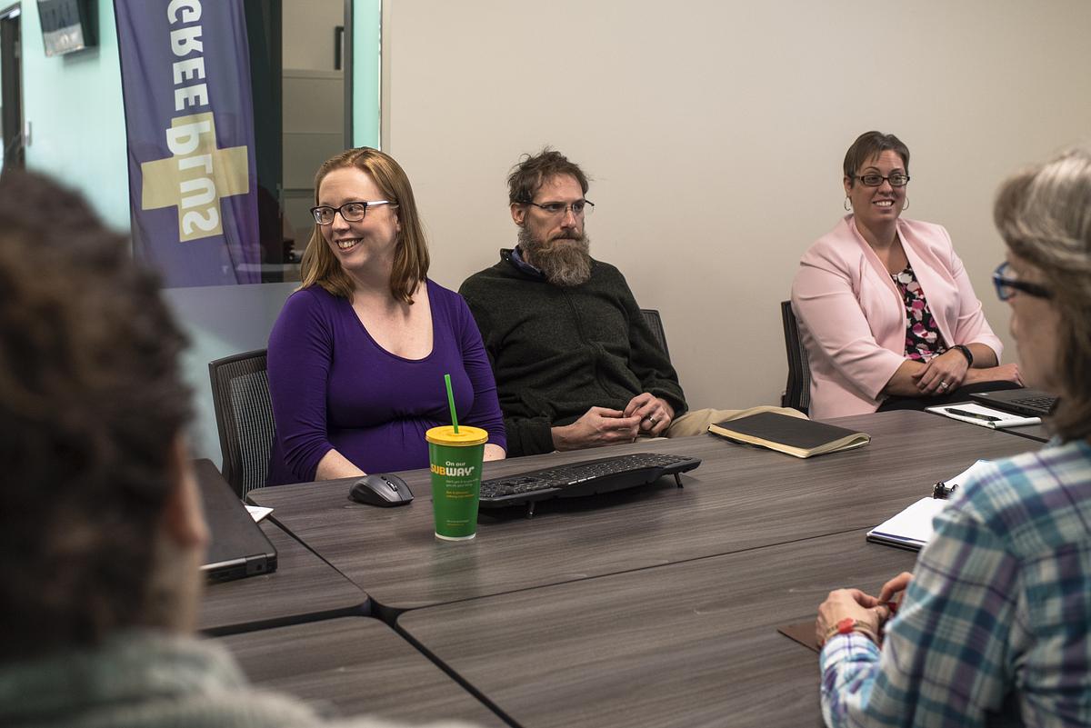 Woman and other professionals sitting around a table having a discussion