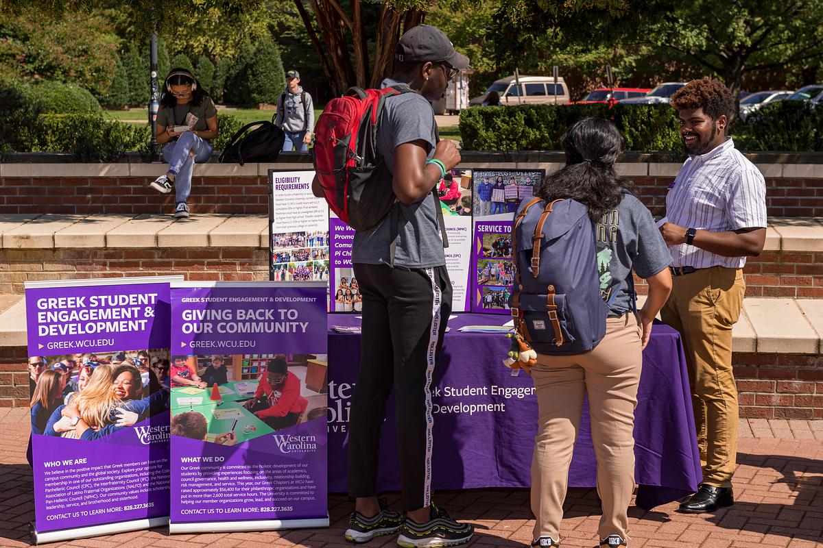 Students looking over material at the health and wellness booth at a Ģ������Ƶfestival