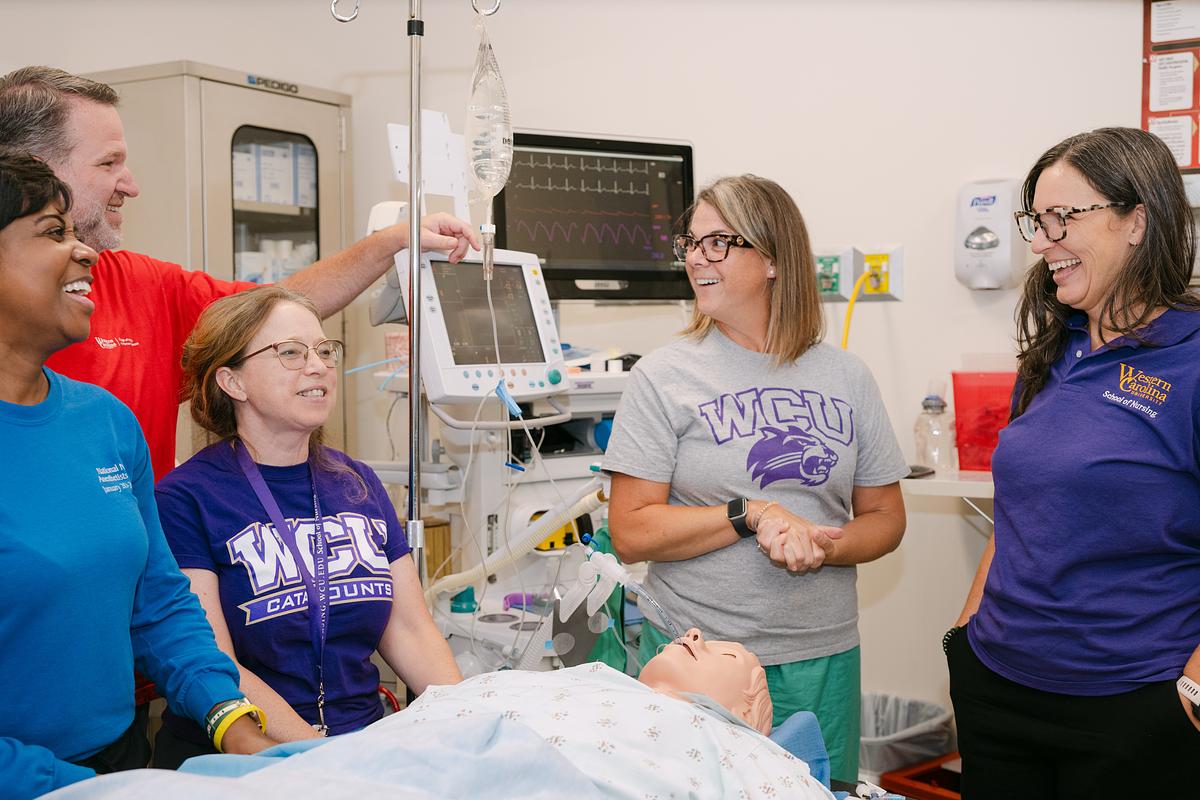Nursing educators and practitioners talking and laughing together in a medical room