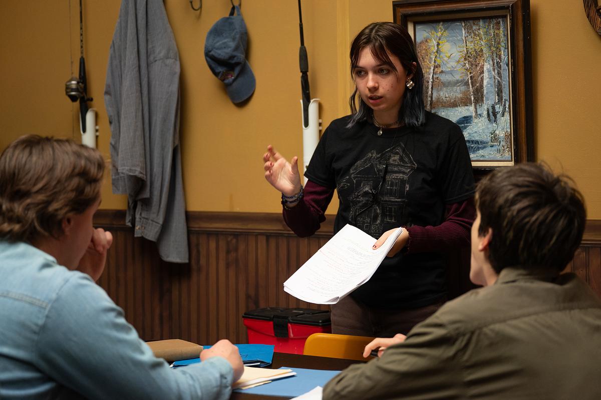 Students discussing a stage and screen script together at a table