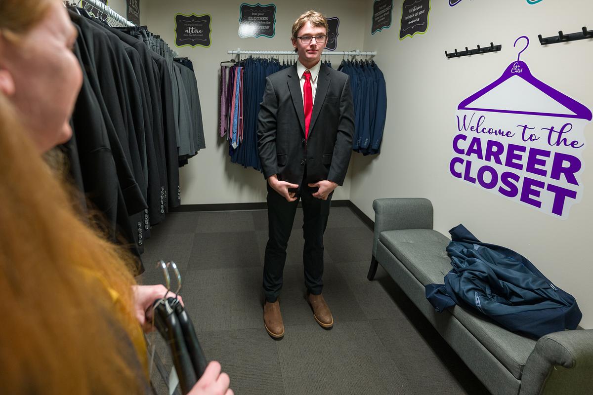 Picture of a student wearing a suit in a dressing room