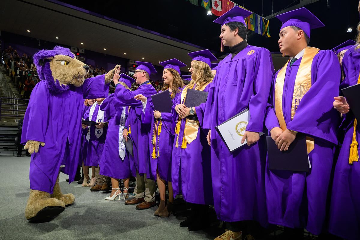 Graduates high-fiving PAWS at Commencement