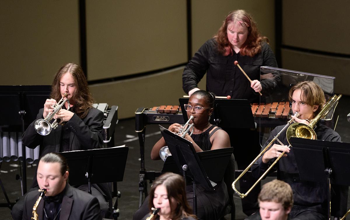 Students performing at the SOM Wind Ensemble playing a variety of instruments together during the porformance