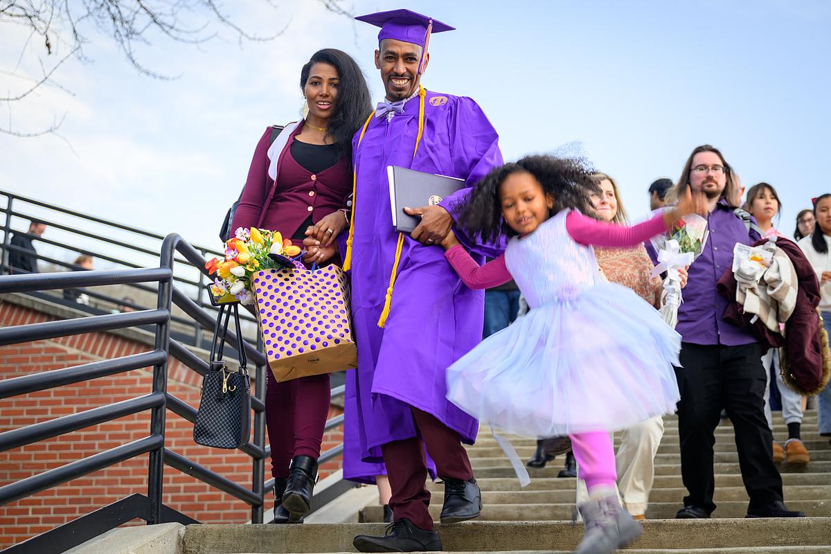 Graduate student and family celebrating at commencement