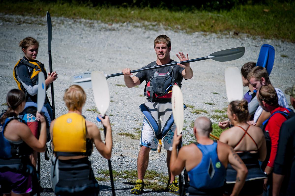 Instructor showing students the proper way to hold and use a paddle