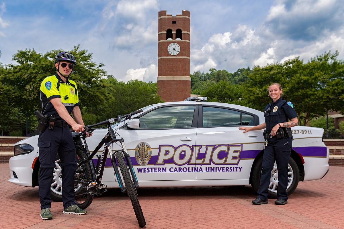 Police officers stand in front of the alumni tower for a photo