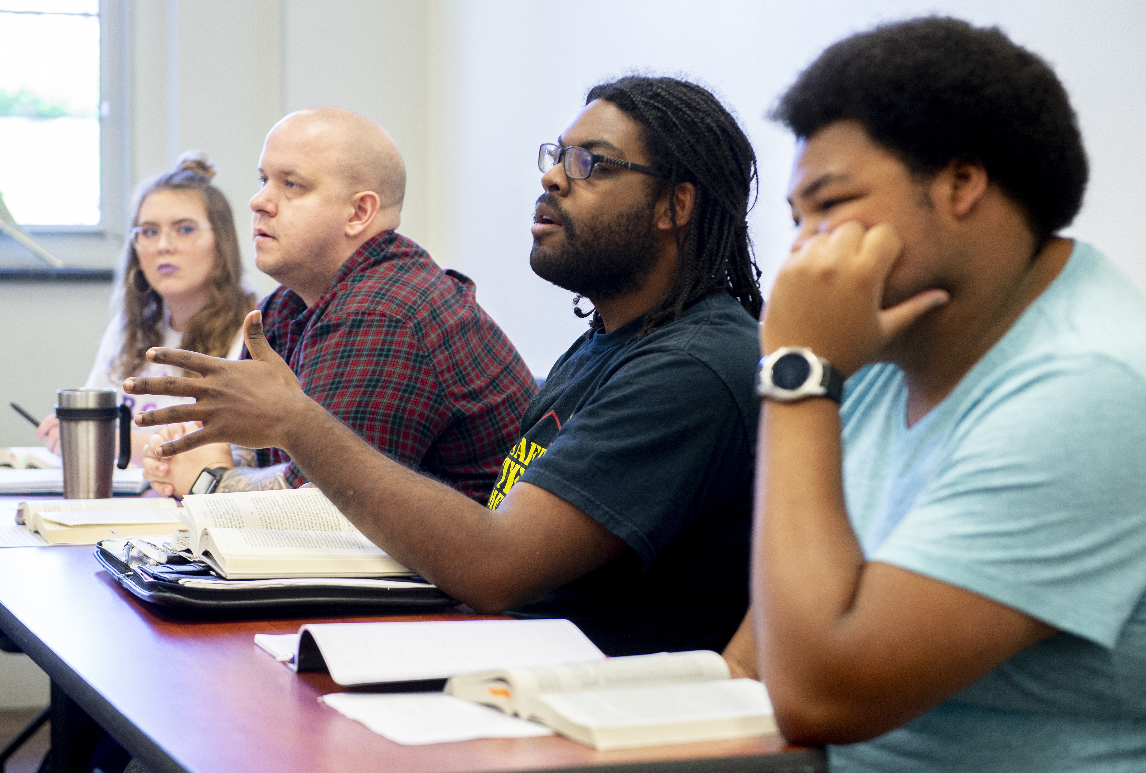 Four students engage in discussion during class.